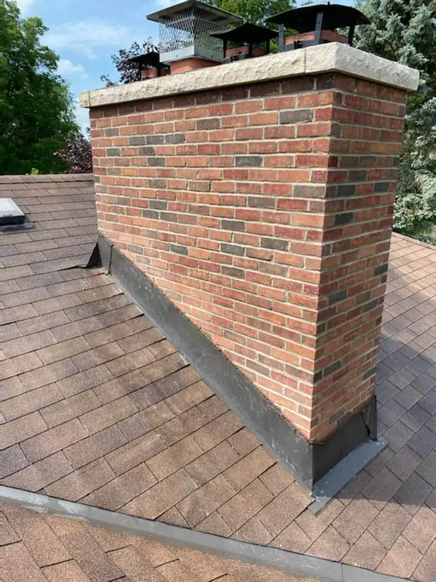 Rebuilt brick chimney with a concrete crown and flue caps